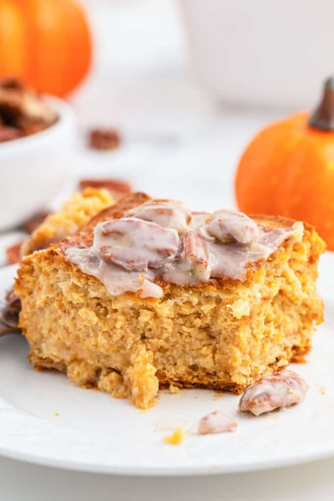 A slice of the pumpkin cake on a white plate, showing a bite shot.