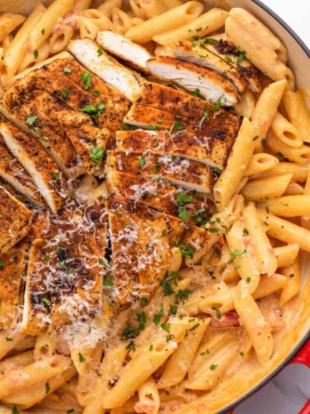 Creamy penne pasta topped with sliced cajun chicken