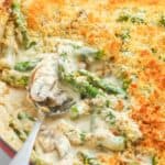 creamy cheesy asparagus casserole topped with panko bread crumbs in an enameled skillet.