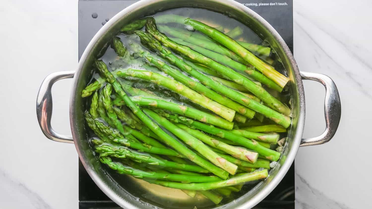 Blanching asparagus in a pot with hot water