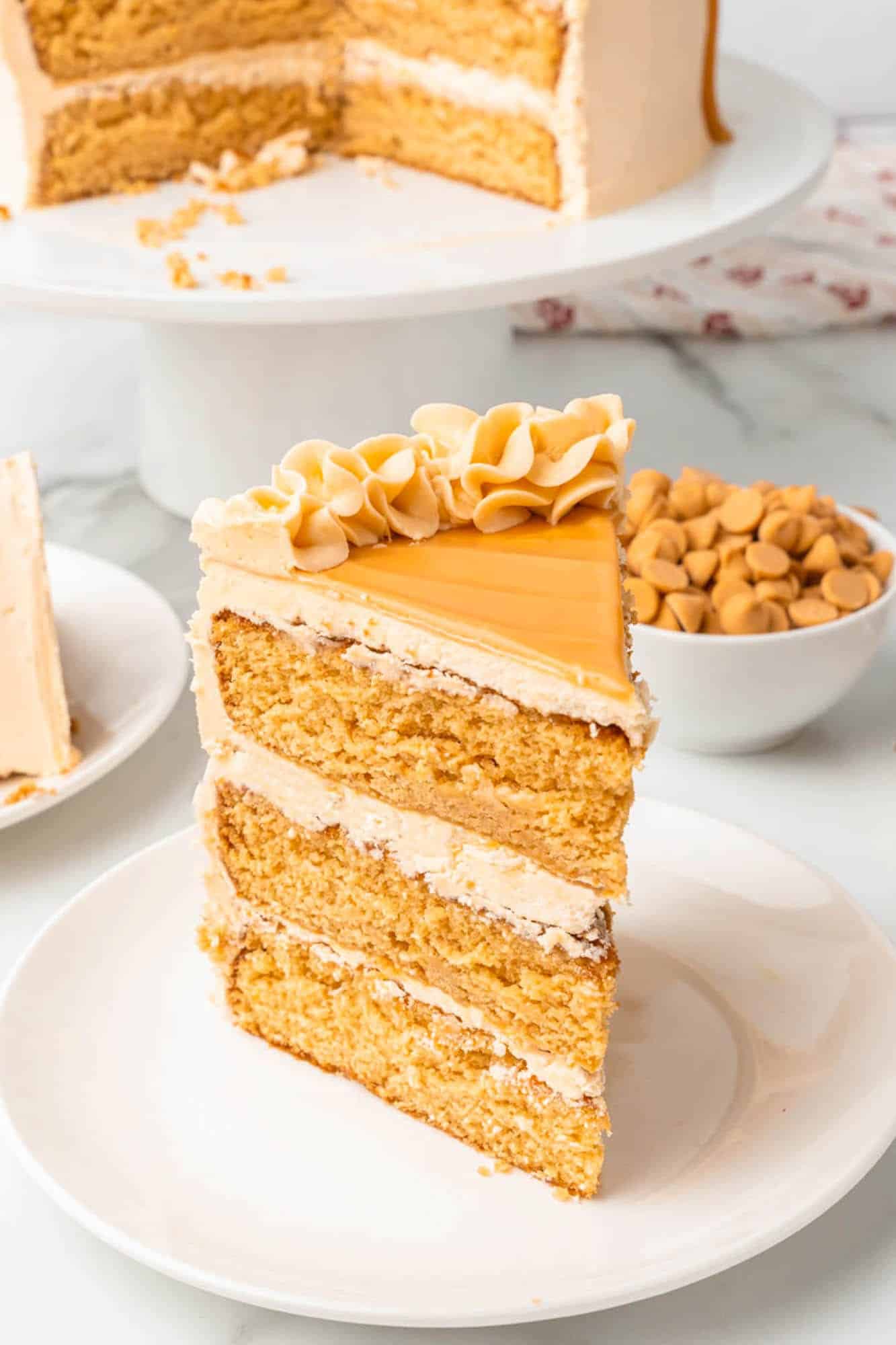 a slice of three layer butterscotch cake on a dessert plate.