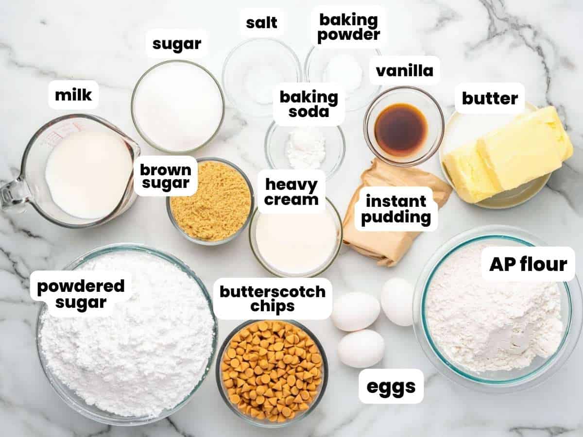 Every ingredient needed to make a butterscotch layer cake with ganache, in separate bowls on a counter. Text boxes label each ingredient.
