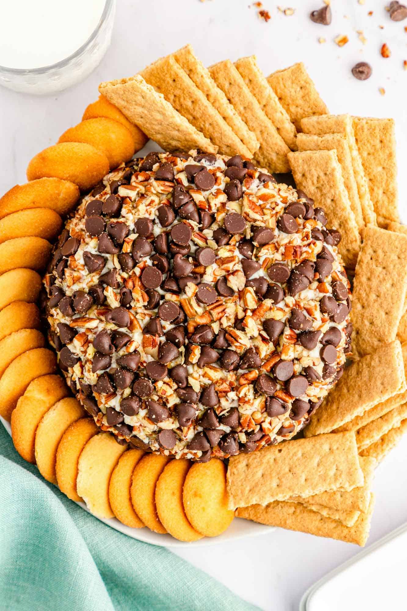 a cream cheese ball with pecans and chocolate chips, surrounded by graham crackers and nilla wafers