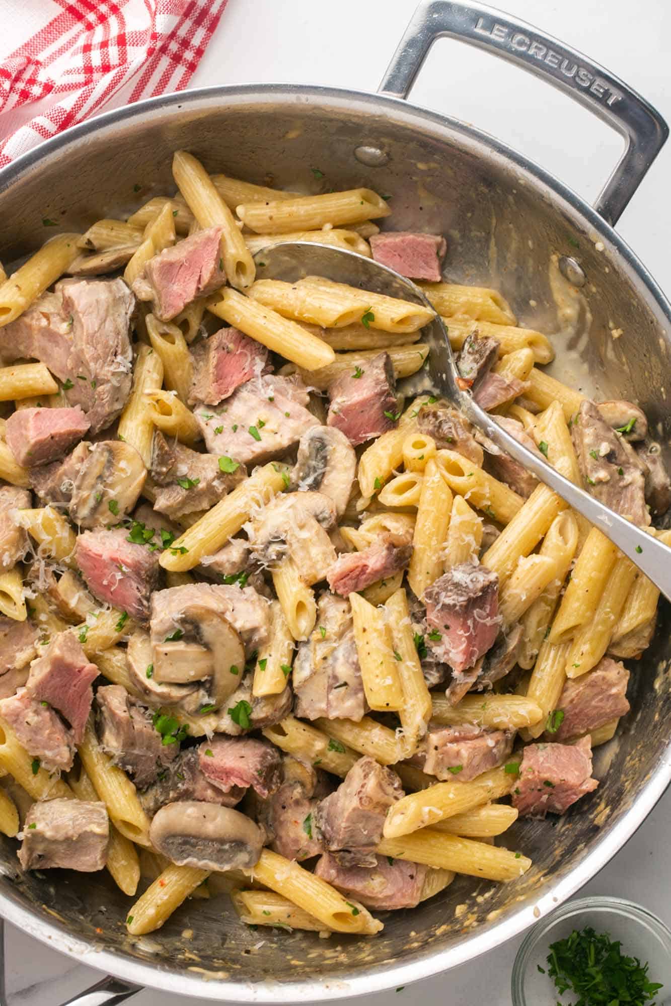 Overhead shot of creamy prime rib pasta in a stainless steel skillet