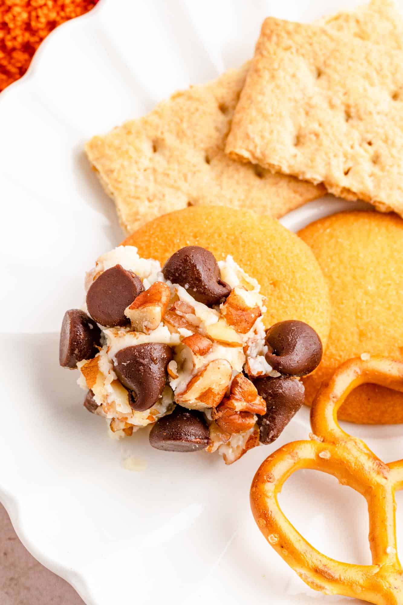 a plate of cookies and a pretzel. One nilla wafer is covered with dessert cheese ball.