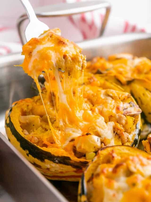A cheese pull of a stuffed acorn squash using a spoon