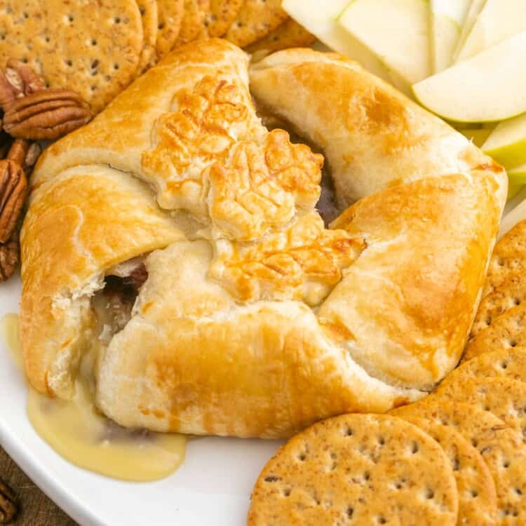 Baked brie in puff pastry served with crackers and thinly sliced apples