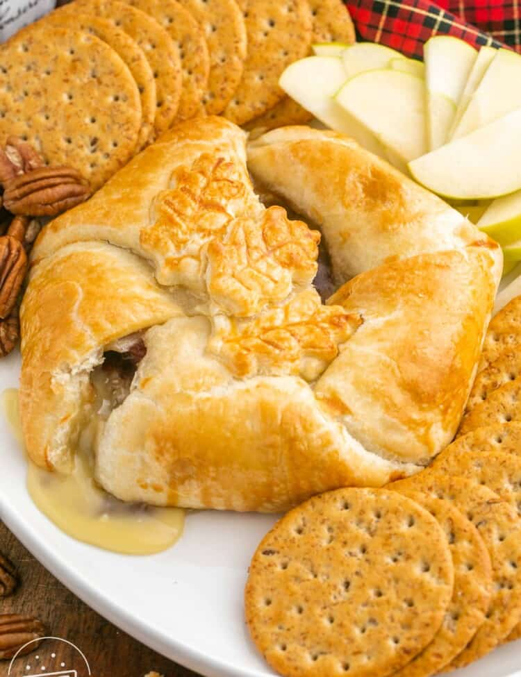 Baked brie in puff pastry served with crackers and thinly sliced apples
