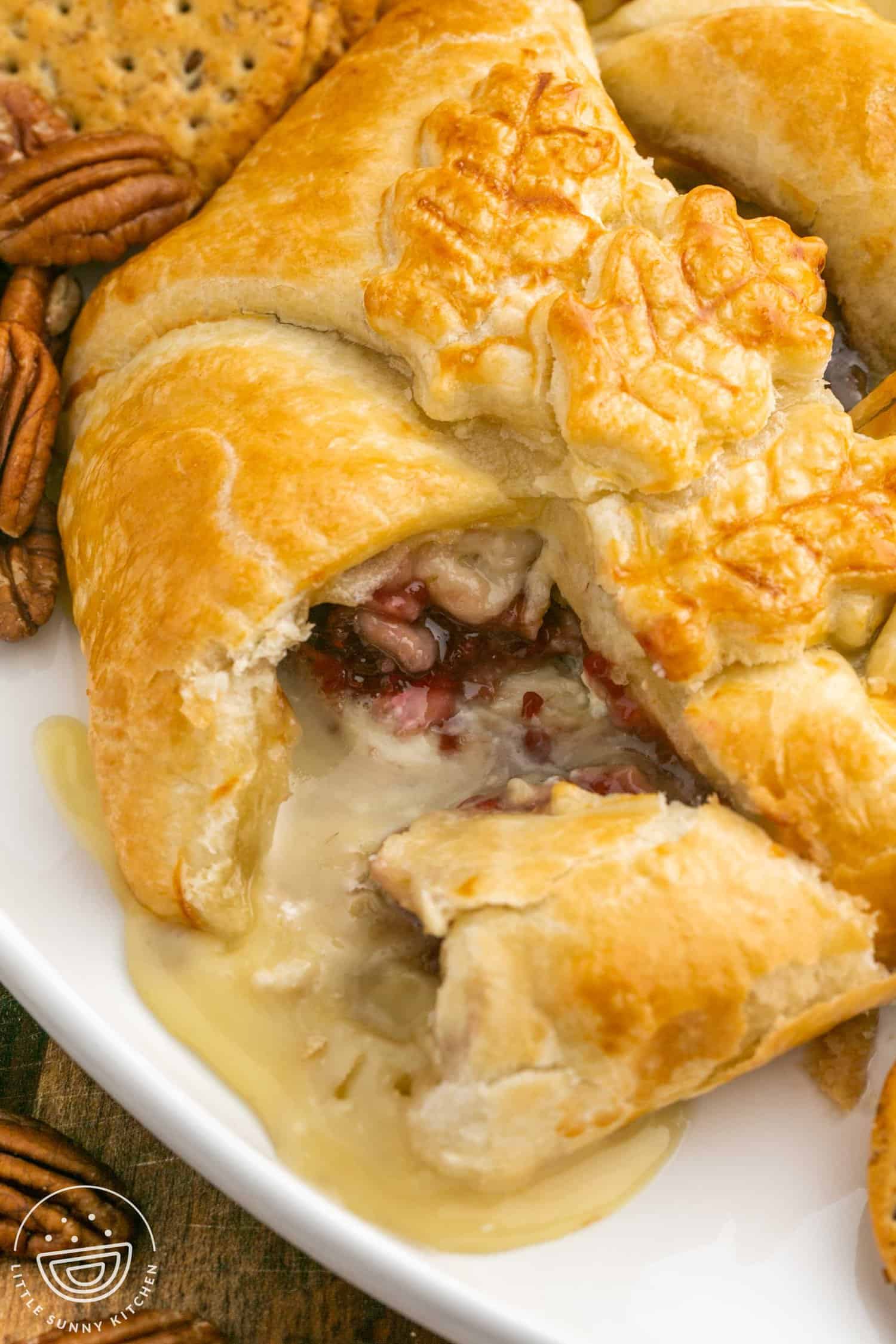 Baked brie in puff pastry and melty cheese oozing out