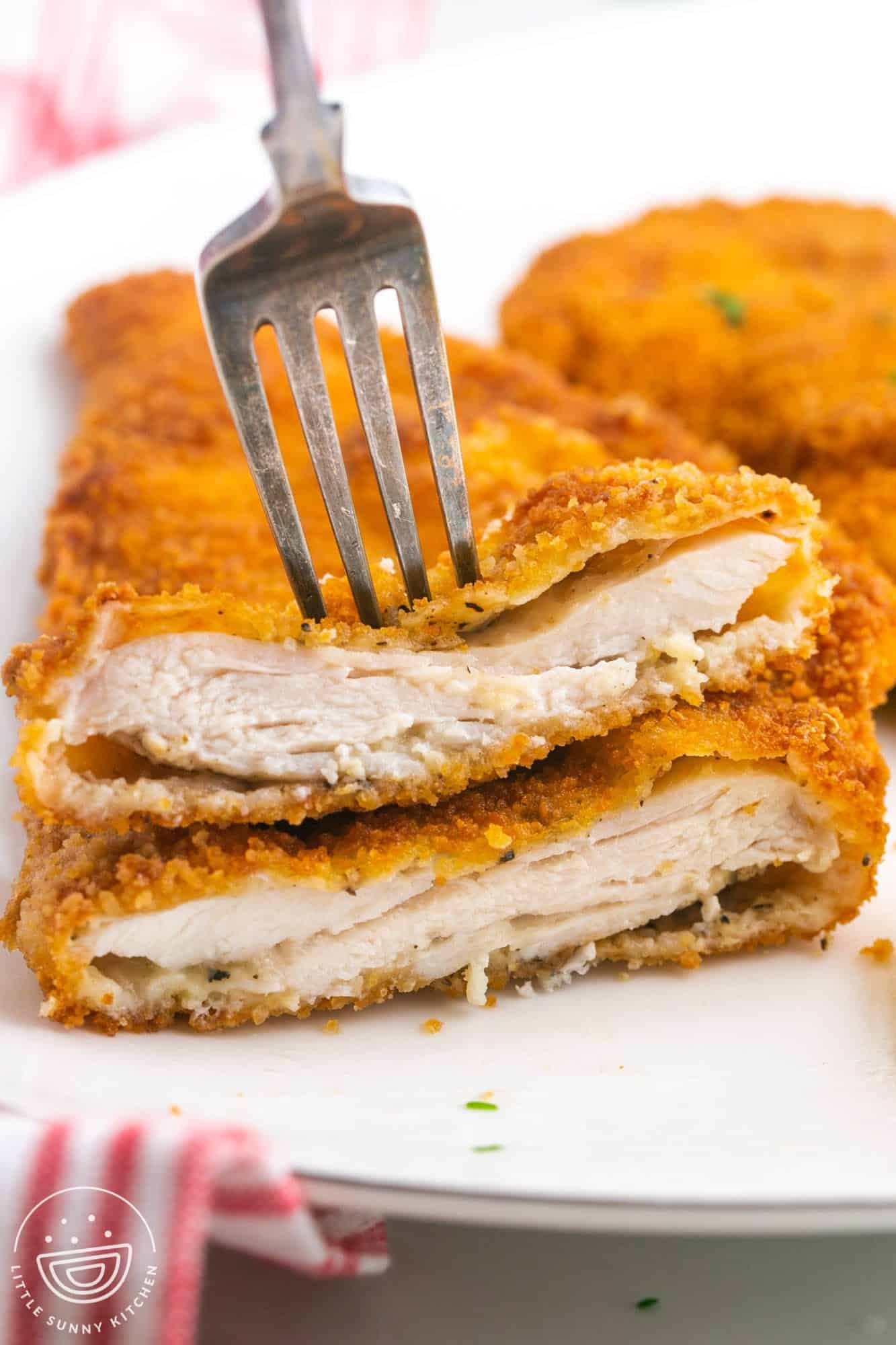 Sliced chicken schnitzel with fluffy pockets, and a fork