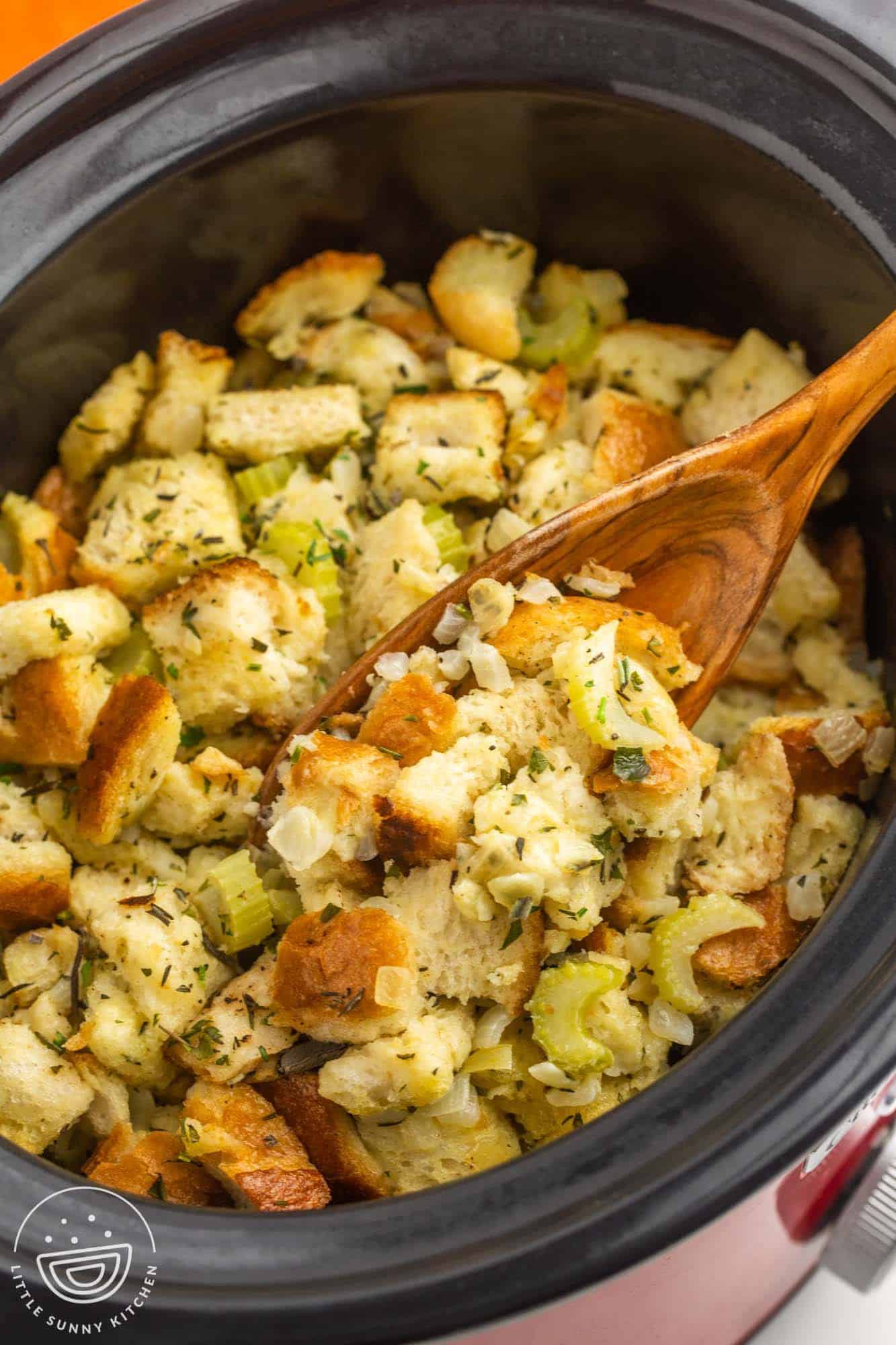 Stuffing in a slow cooker with a wooden spoon