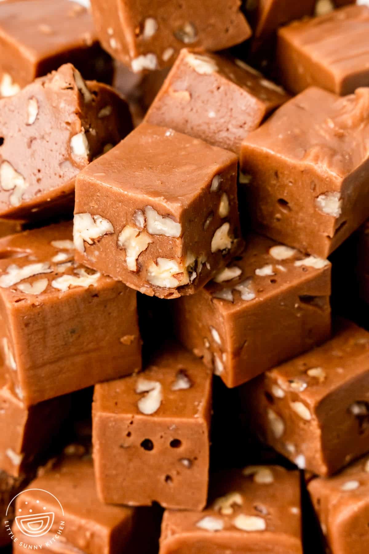 closeup of a stack of fudge squares with walnuts inside. 