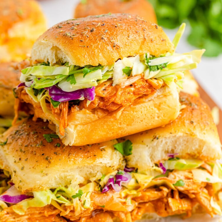 a stack of bbq chicken sliders on hawaiian rolls with coleslaw.