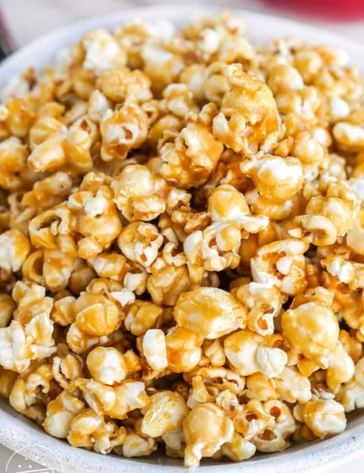 a large white bowl filled with caramel popcorn.