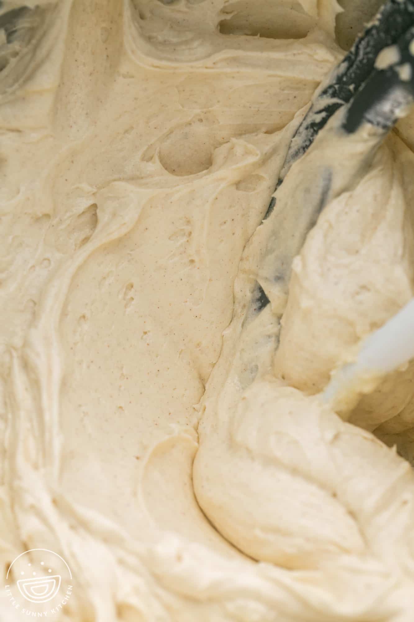 Close up shot of whipped cinnamon cream cheese frosting in a stand mixer bowl