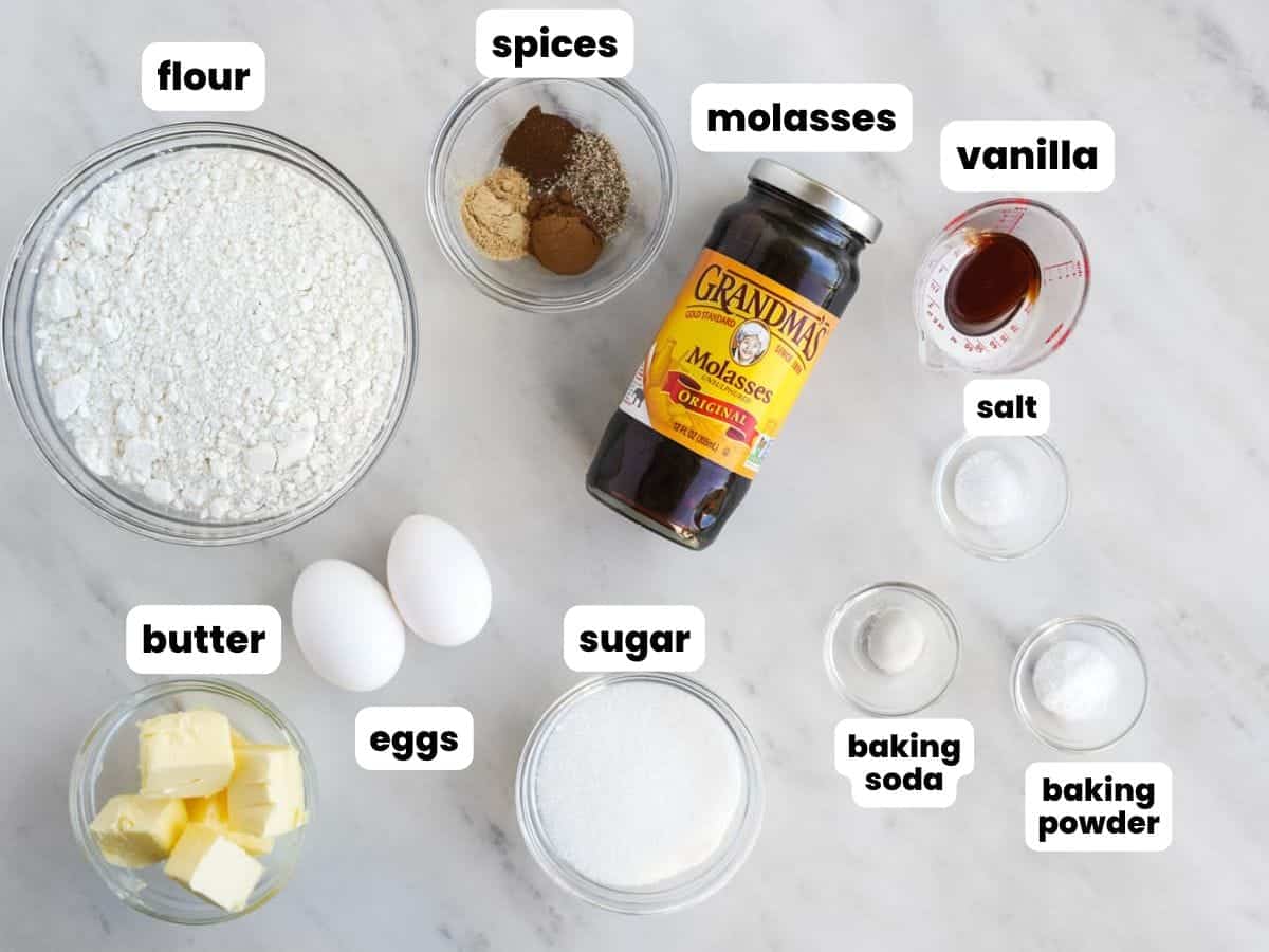 the ingredients in gingerbread cake, arranged on a counter and viewed from above. Each ingredient is labeled with a white text box.