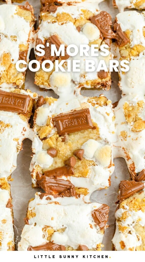 overhead photo of a batch of smores bars with marshmallows and chocolate bars on top. The bars have been cut apart to show the gooey marshmallow creme. Text overlay says "s'mores cookie bars"