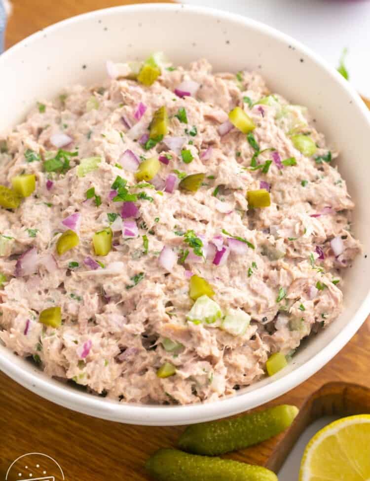 a white bowl filled with homemade tuna salad with pickles.