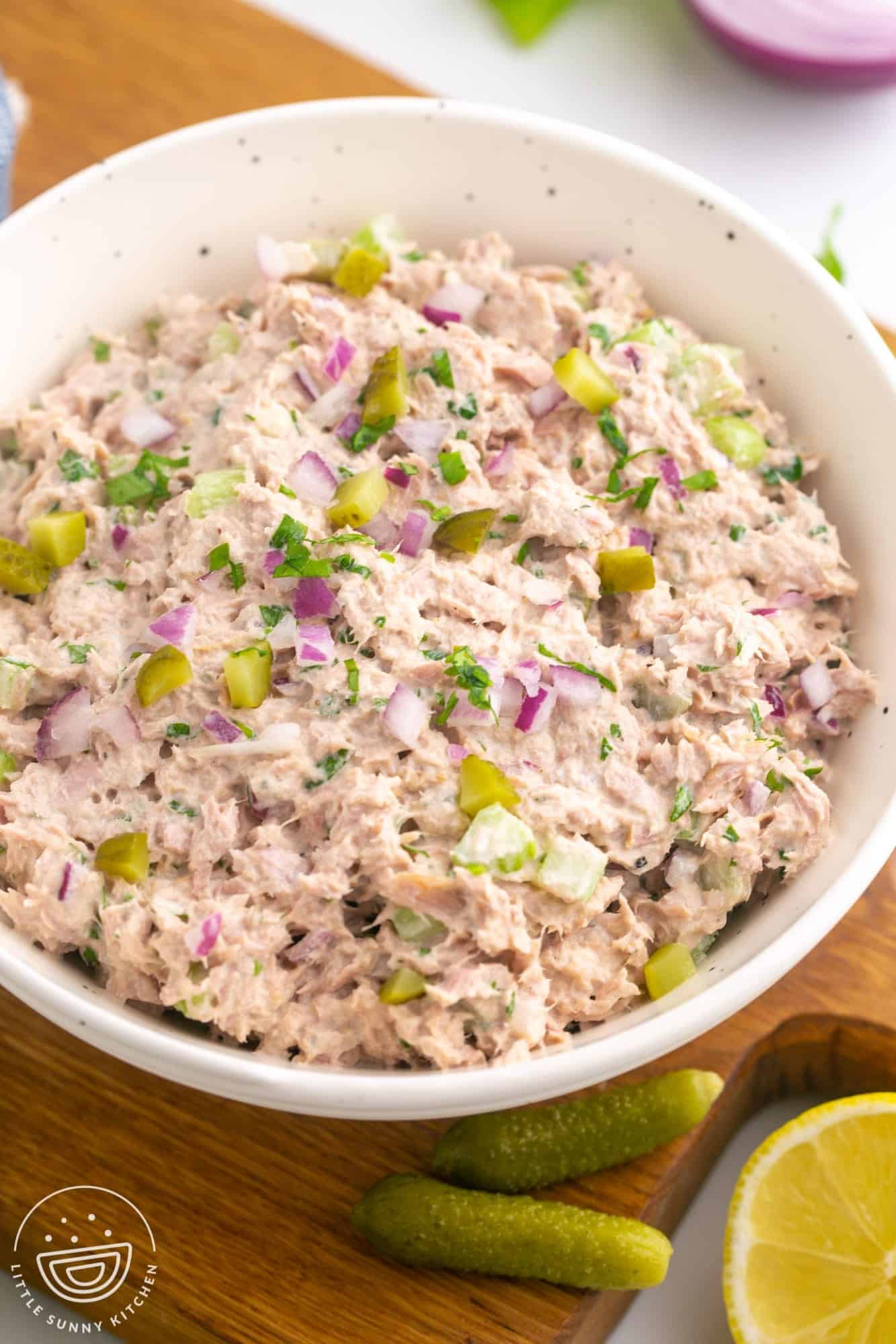 a white bowl filled with homemade tuna salad with pickles. 