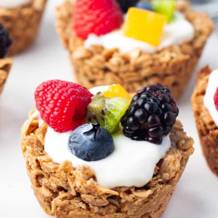 muffin sized cups made with oats. they are filled with yogurt and various fresh fruit.