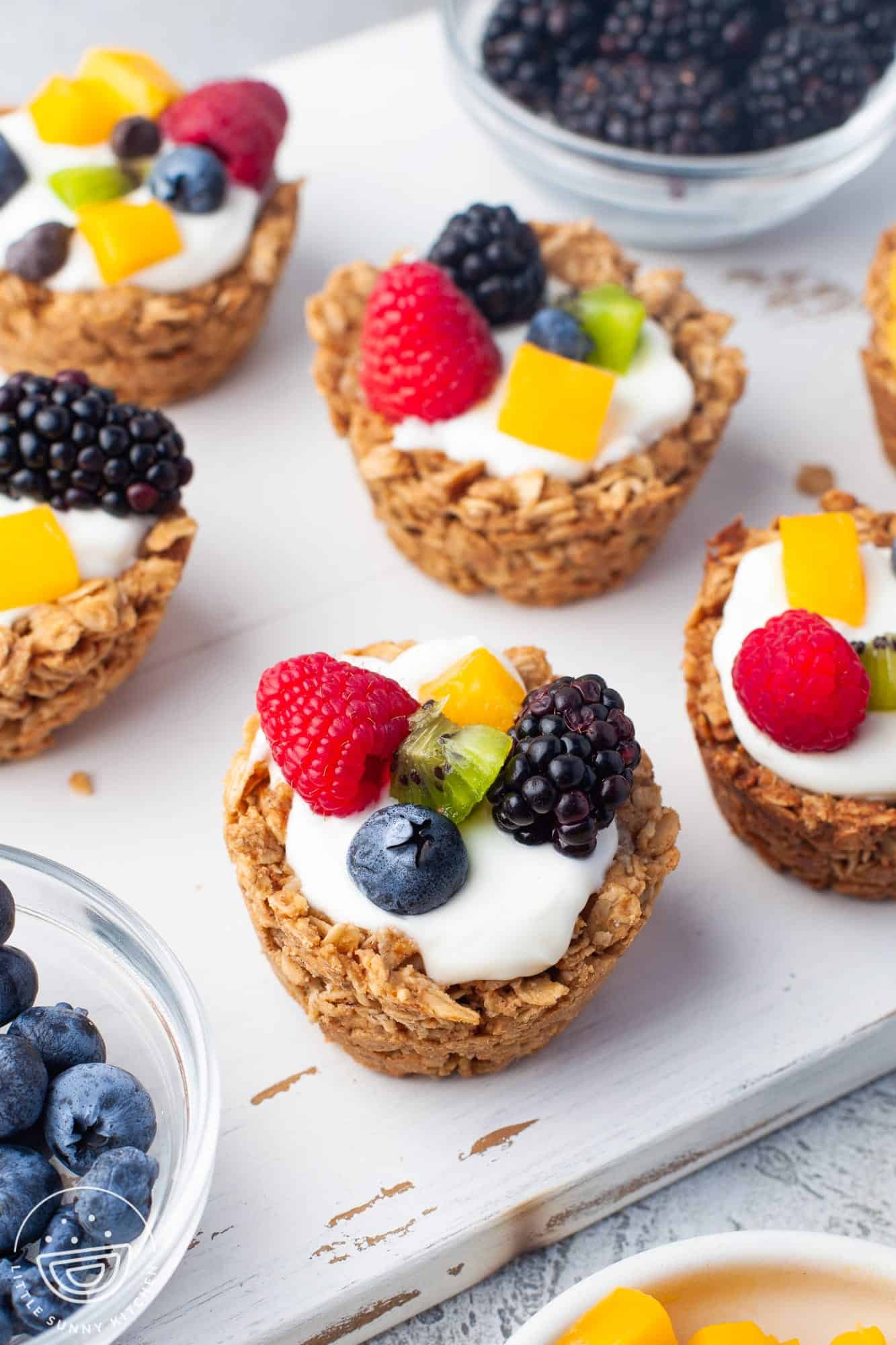 a board holding several baked oatmeal cups with fruit and yogurt