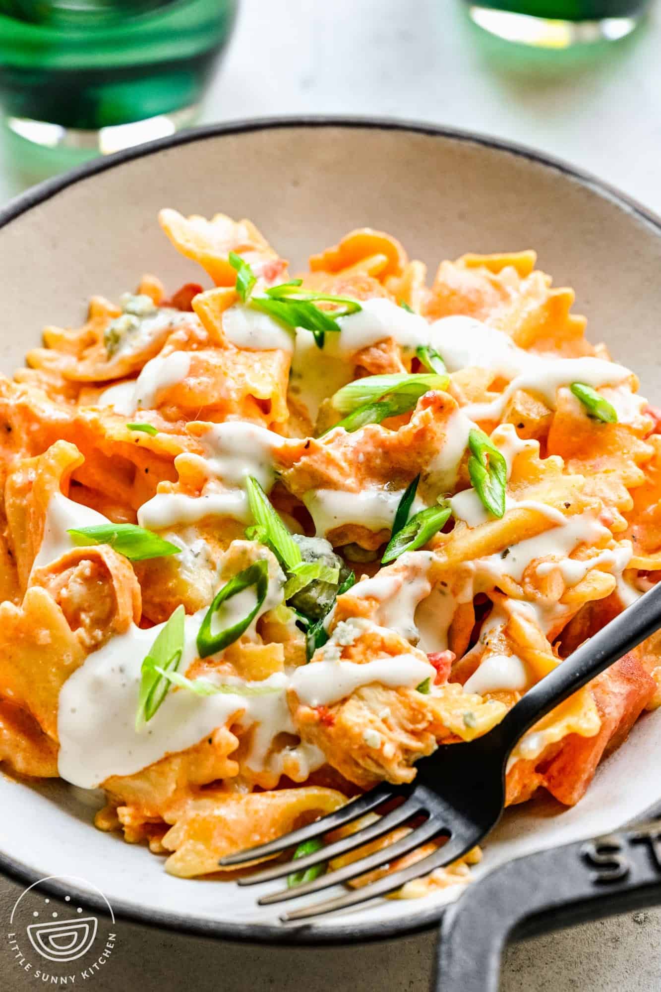 one serving of bufalo chicken pasta with creamy sauce and blue cheese on top.