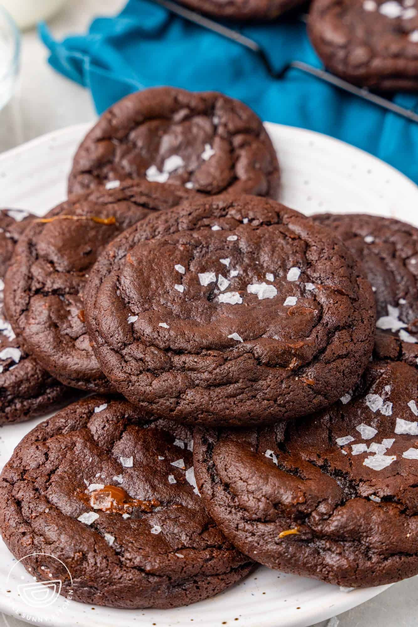 a plate of chocolate caramel cookies topped with sea salt.
