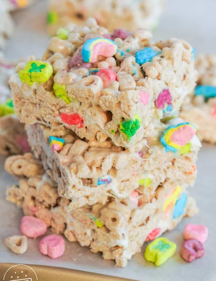 3 stacked lucky charms treats on a metal tray lined with parchment paper