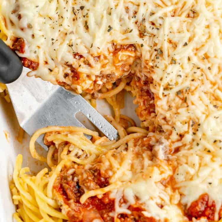 a spatula serving spaghetti pie from a casserole dish.
