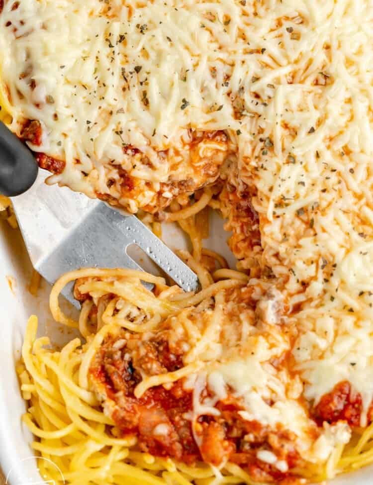 a spatula serving spaghetti pie from a casserole dish.