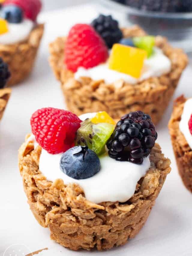 muffin sized cups made with oats. they are filled with yogurt and various fresh fruit.