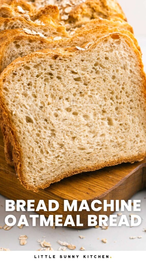 A slice of oatmeal bread on a wooden cutting board, showing the crumb. And overlay text that says "bread machine oatmeal bread"