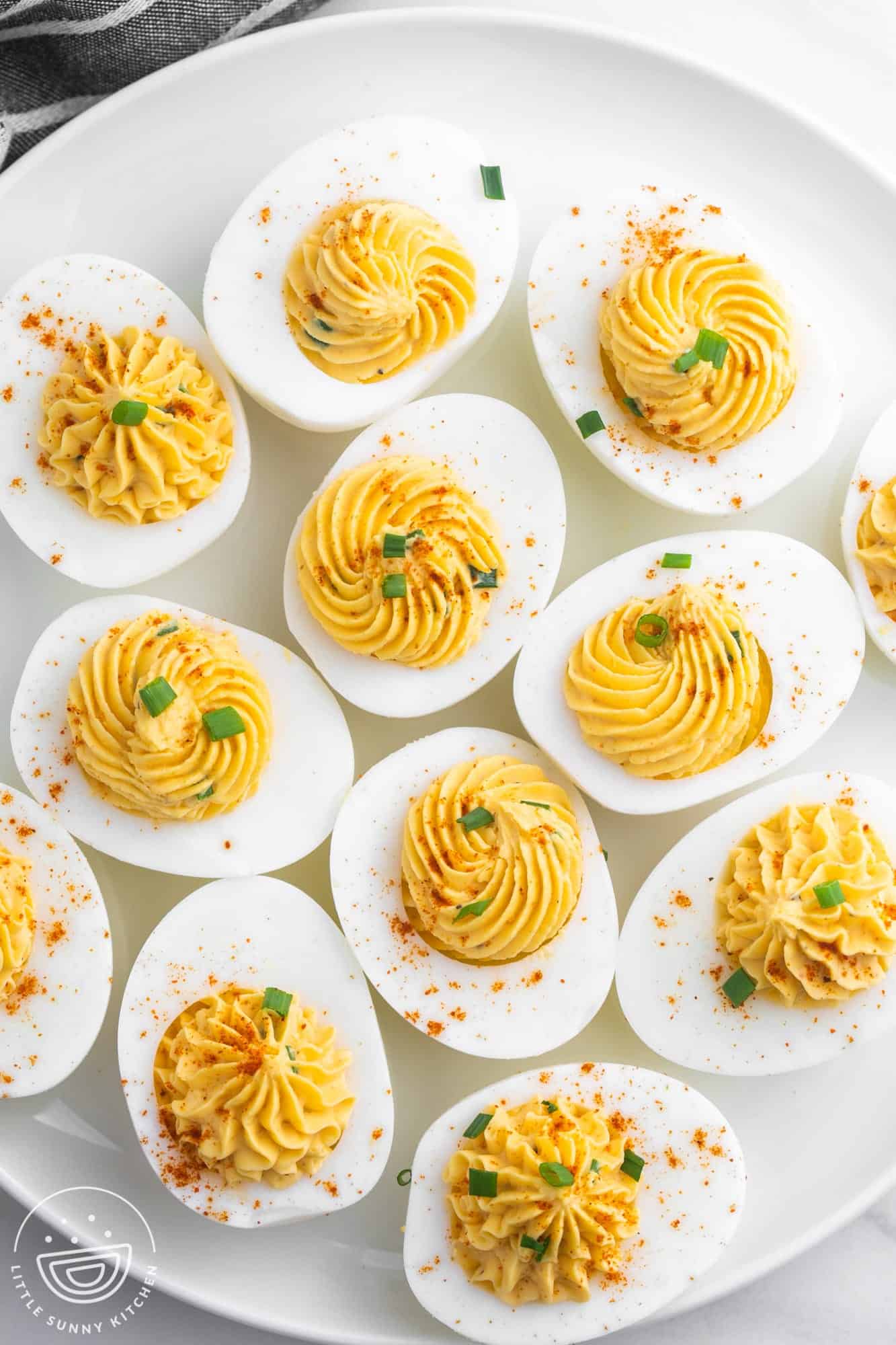 a white platter filled with deviled eggs, viewed from above.