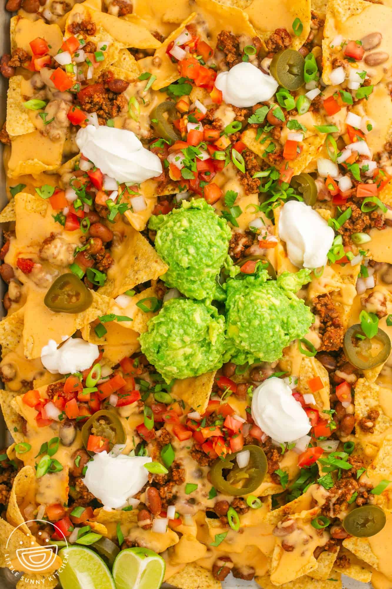 A tray of nachos, loaded with toppings.