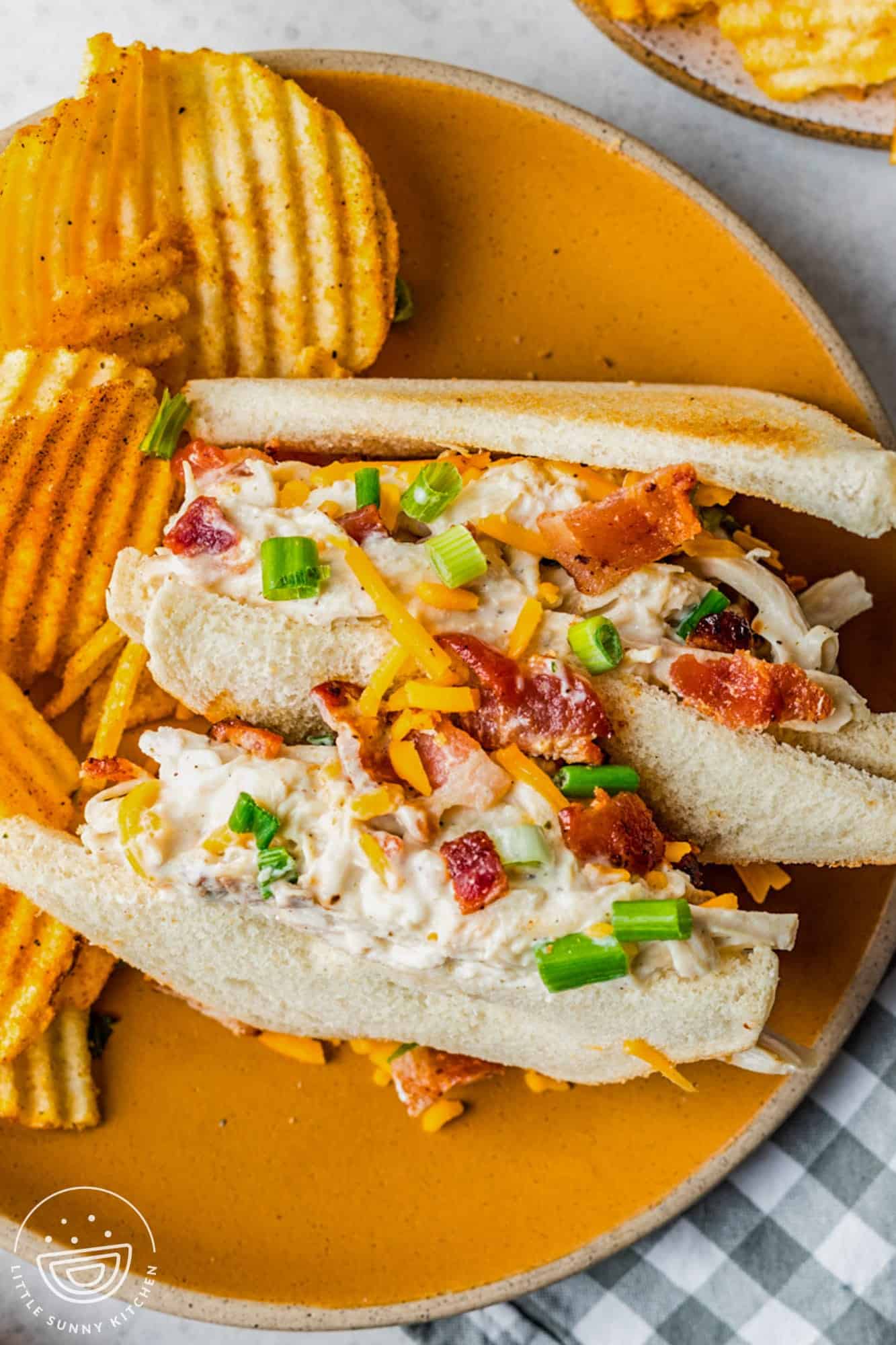 instant pot crack chicken sandwiches on toast, on a plate with barbecue potato chips