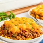 a plate filled with a large portion of sloppy joe casserole with tater tot topping