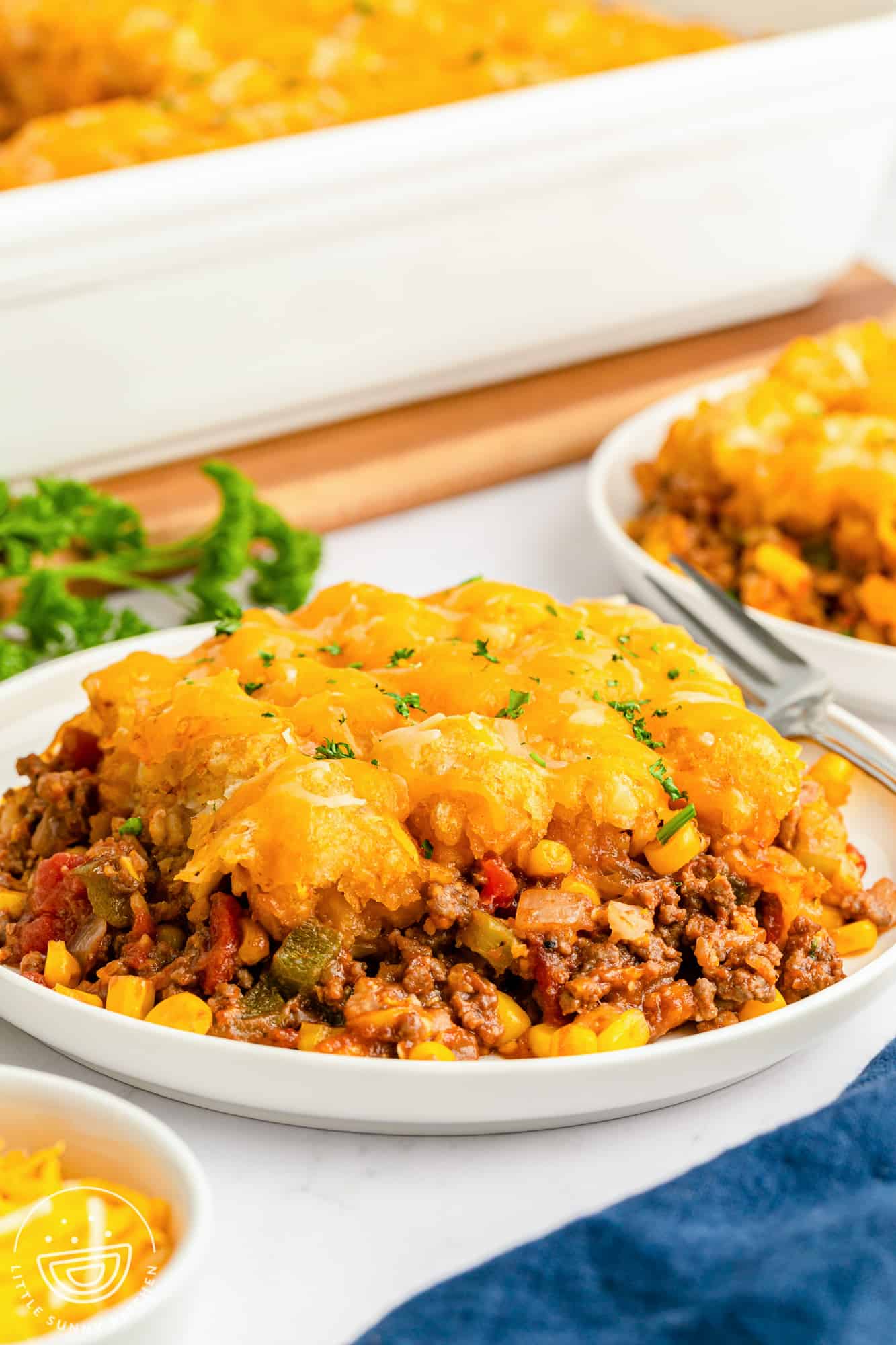 a plate filled with a large portion of sloppy joe casserole with tater tot topping