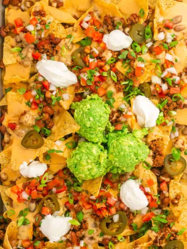 A tray of nachos, loaded with toppings.