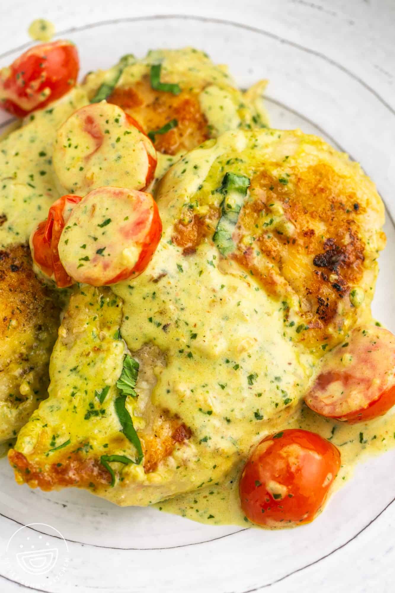 chicken breasts with creamy pesto sauce on a plate.