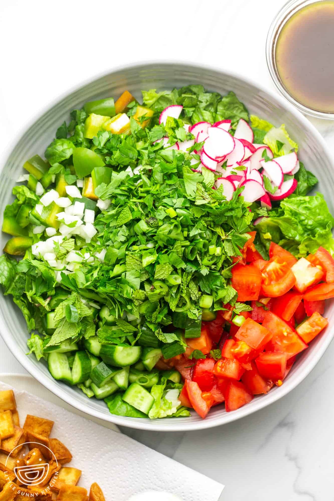The ingredients for fattoush salad, loaded into a large bowl.
