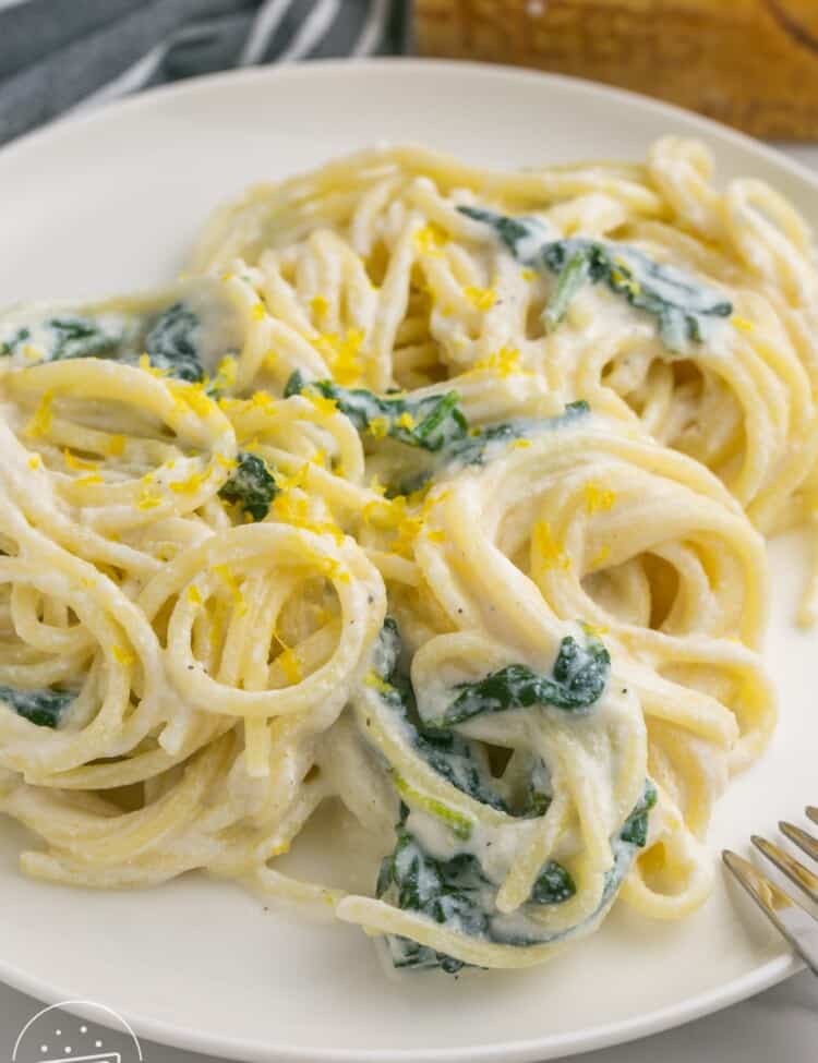 creamy lemon ricotta pasta with spinach on a plate.