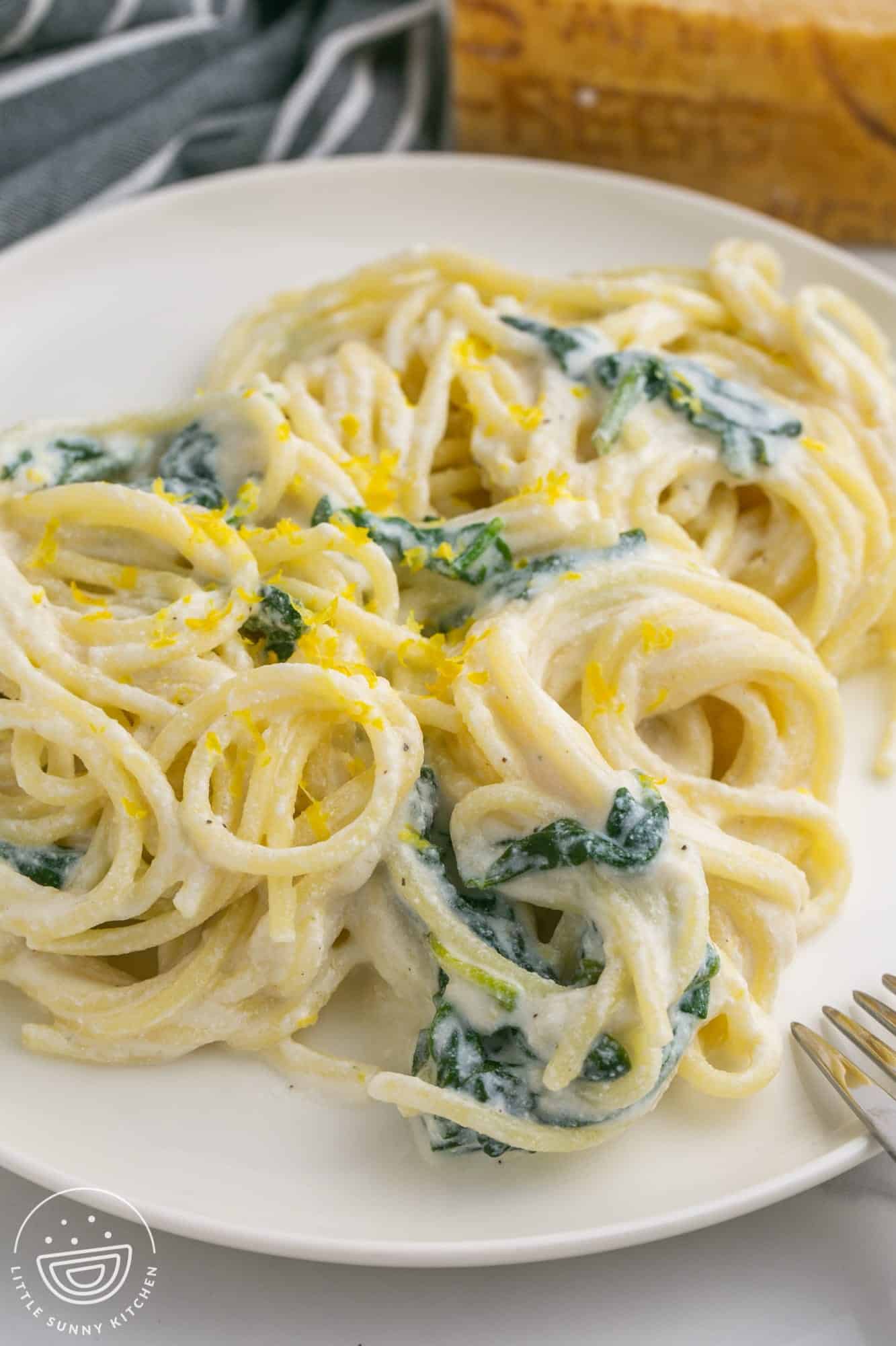 creamy lemon ricotta pasta with spinach on a plate.