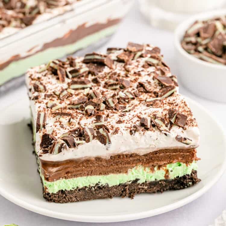 a square piece of chocolate lasagna with layers of oreo crumbs, mint pudding, chocolate pudding, and whipped topping.