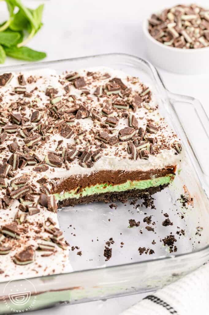 mint chocolate lasagna in a glass baking dish, one piece has been removed from the front corner.