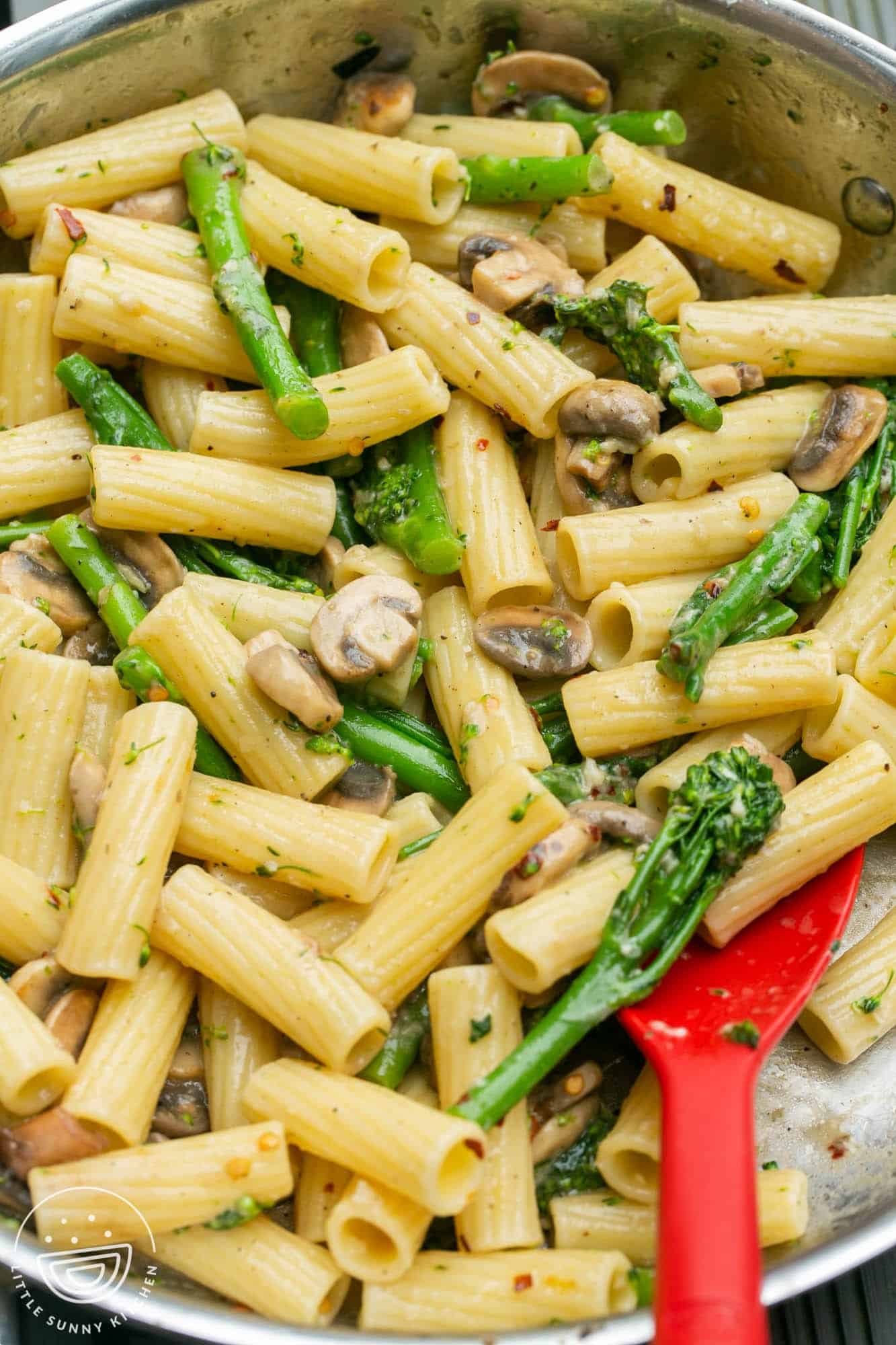 Rigatoni with mushrooms and broccolini in a skillet.