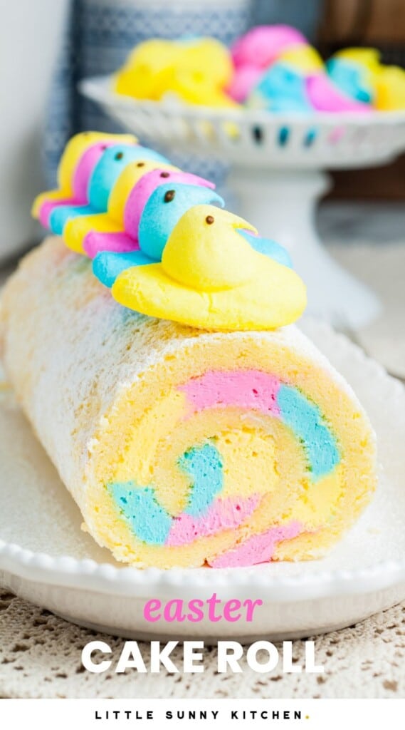 a vanilla cake roll with pink, blue, and yellow icing inside, topped with chicks peeps. Text overlay says "easter cake roll"
