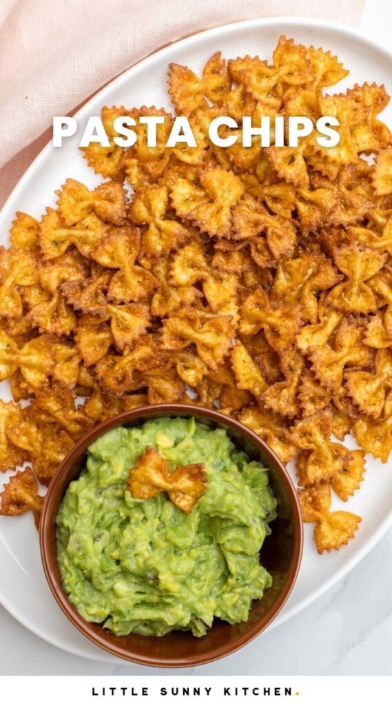 Pasta chips served on a white platter with a small bowl of guacamole