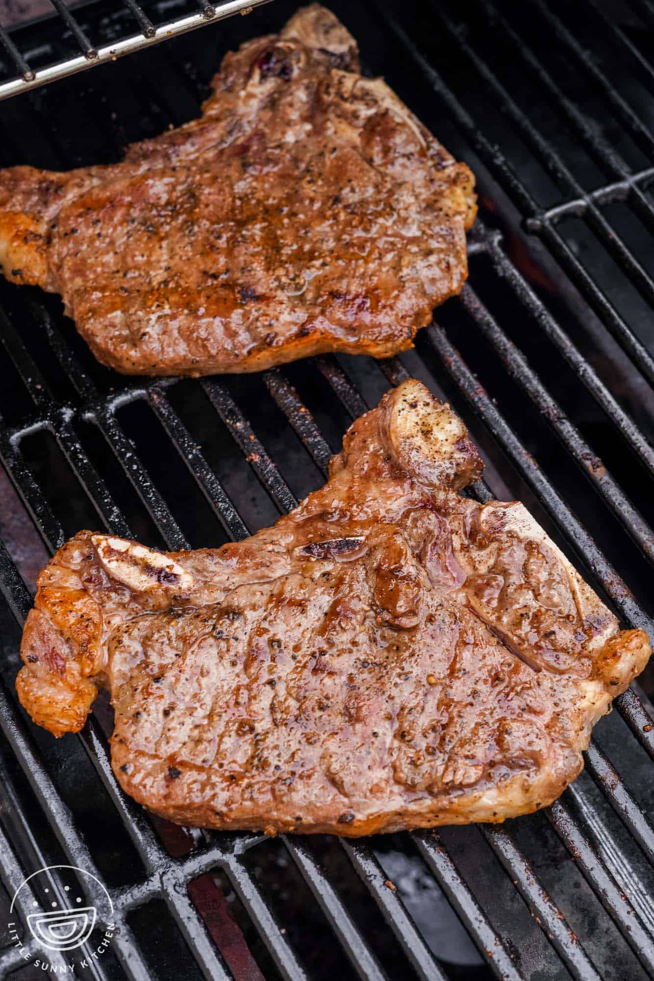 Two cooked T bone steaks on a grill. 