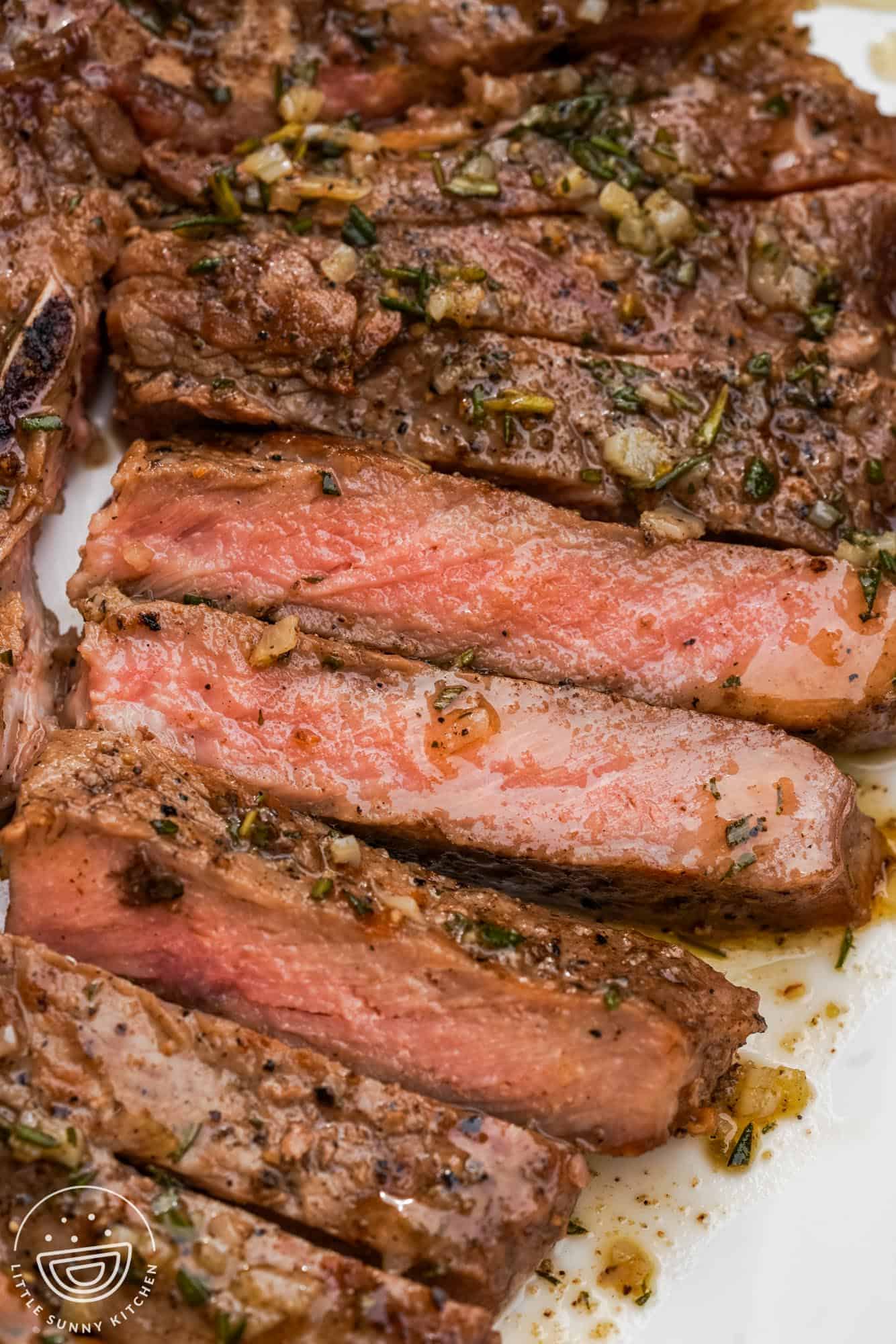 sliced medium rare grilled t bone steak.