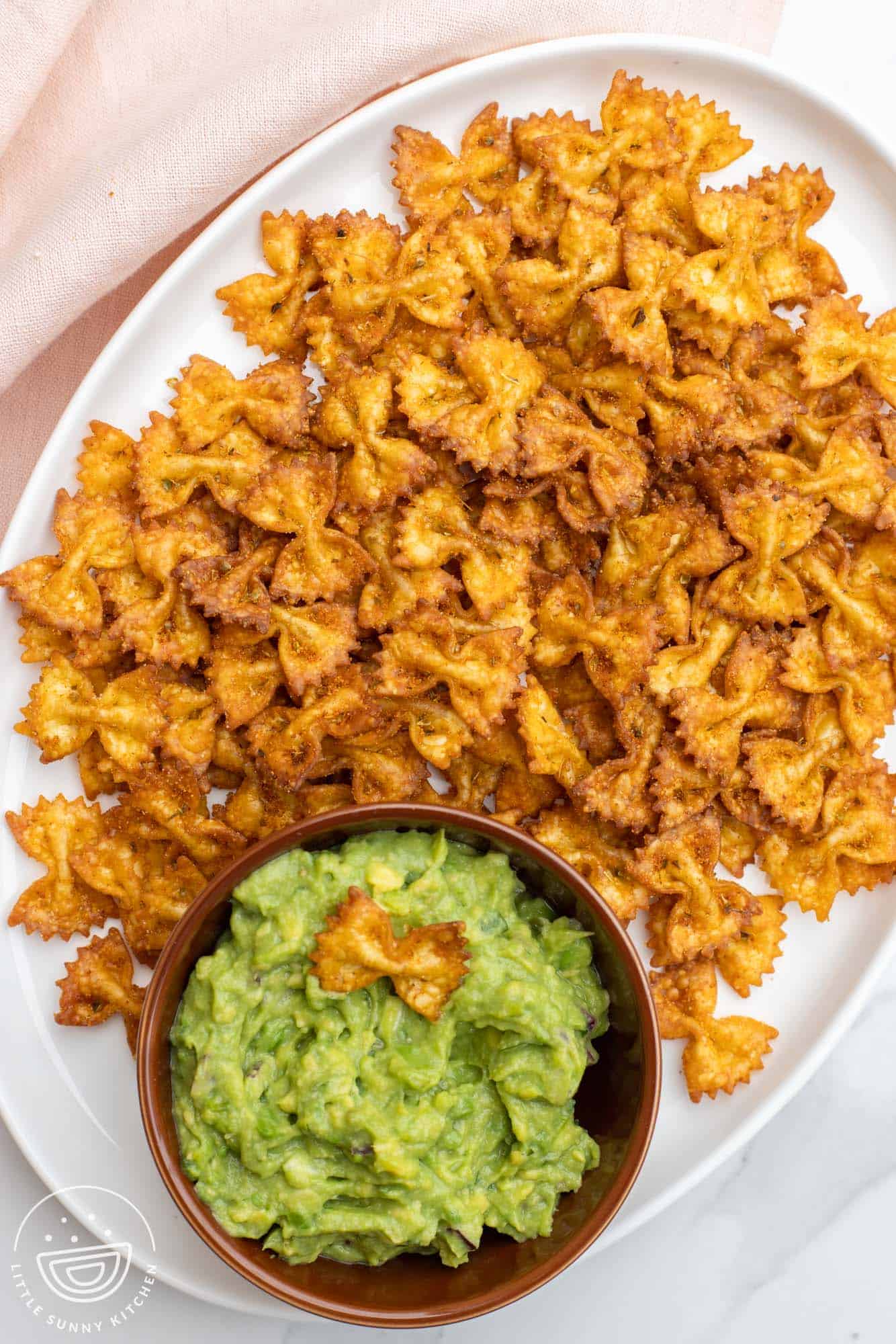 Overhead shot of pasta chips served with guacamole for dipping